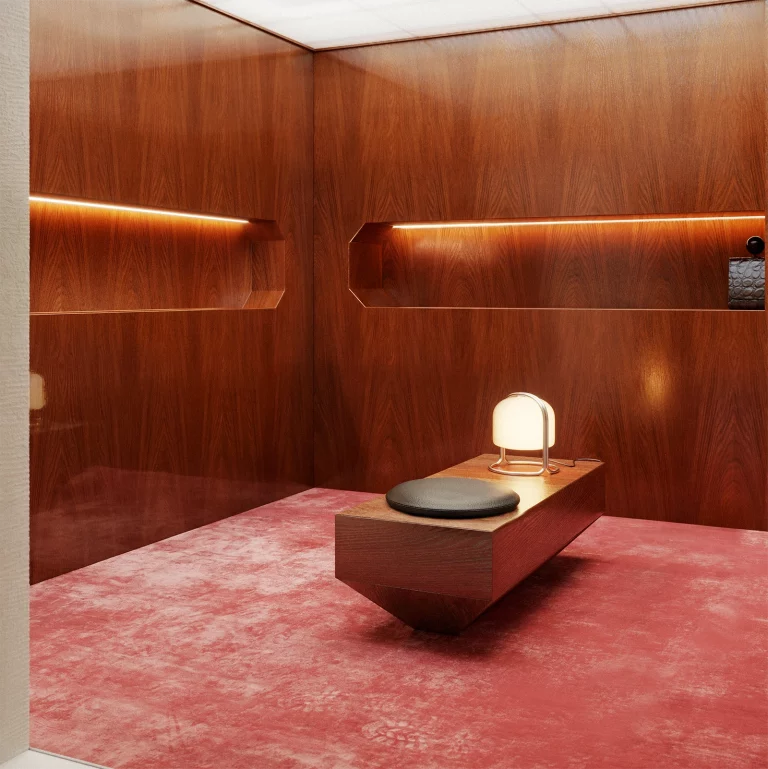 NOVU concept store by NOCOD Studio — private listening booth. Warm oak panels, LED recessed niche, custom bench with black leather cushion, deep rose velvet carpet