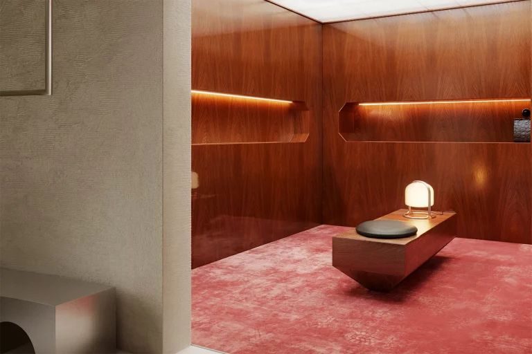 NOVU concept store by NOCOD Studio — transition between private booth (oiled oak, rose carpet) and main space (raw textured plaster, arched threshold).