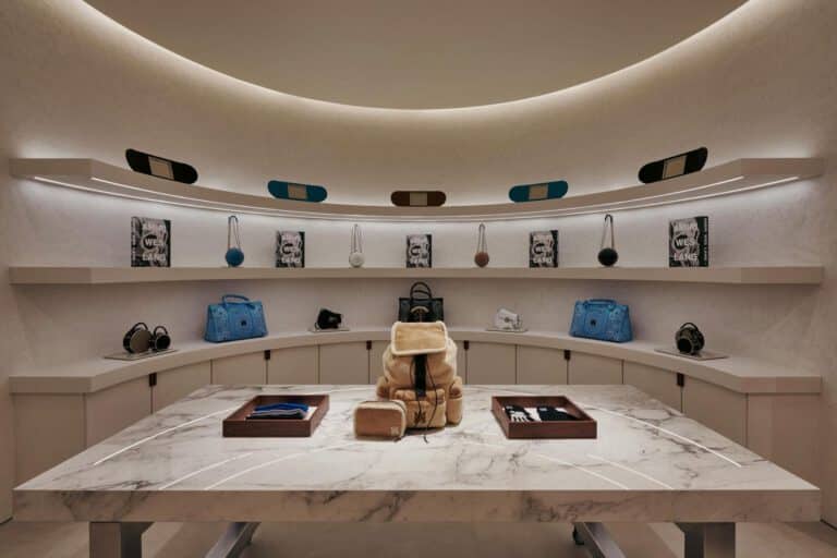 AMIRI Chicago customization atelier by NOCOD Studio, curved intimate room with central marble worktable and integrated display.